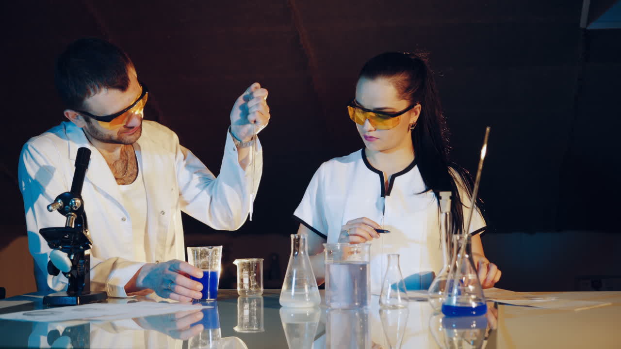 Young scientists conducting tests or research in the laboratory. Lab technician checks the test tubes.