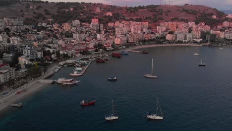 Langsame-Drohne-Kippt-über-Die-Wunderschöne-Bucht-Von-Saranda-Mit-Geparkten-Booten-Und-Yachten