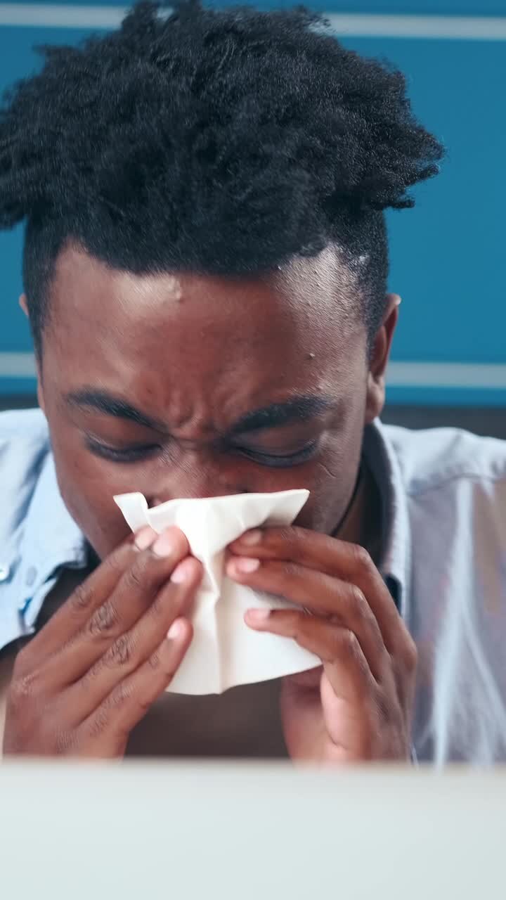 Man struggles with allergies during springtime in a bustling city cafe