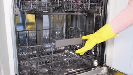 empty dishwasher after work a man in rubber gloves closes the dishwasher door
