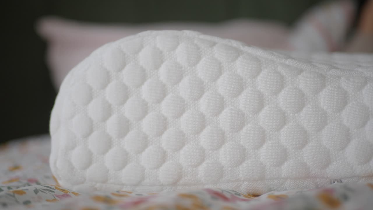 primer plano de una almohada blanca acolchada en una cama