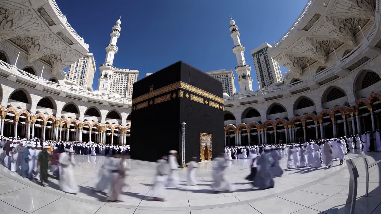 Wide-angle video shot of the Kaaba surrounded by worshippers in traditional attire