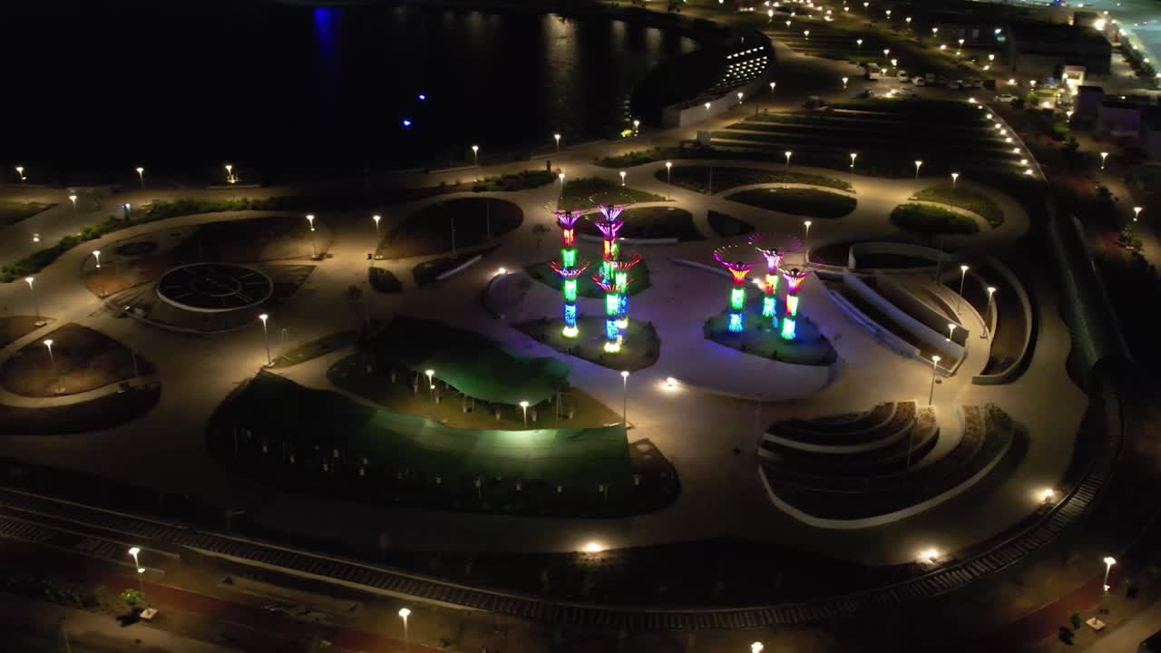 A large colorful fountain moving forward and people watching