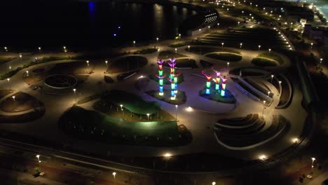 a large colorful fountain moving forward and people watching