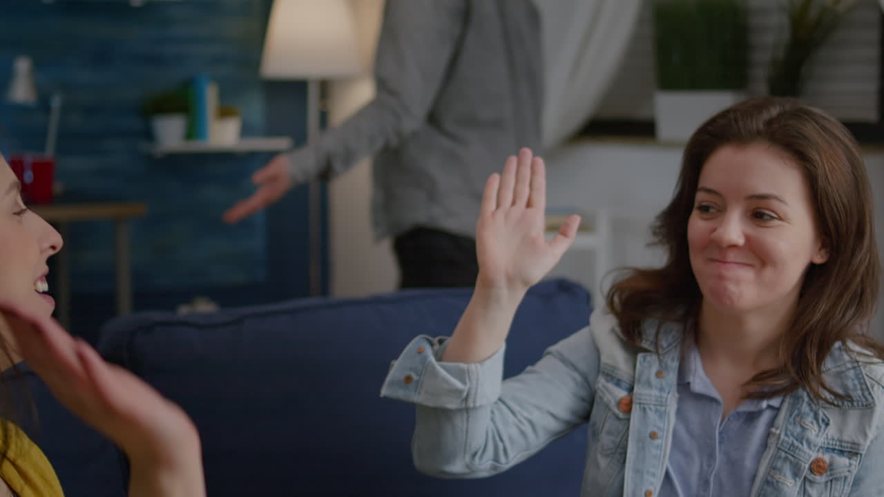 두 명의 여성이 생일 파티에서 웃으며 다섯을 맞추고 있습니다.