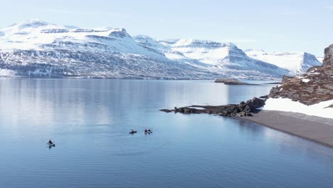 Adventure-kayakers-in-stunning-Iceland-landscape,-background-white-mountains