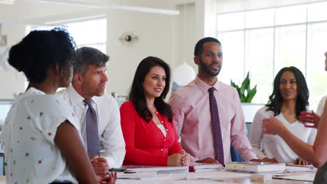 Female-boss-and-team-meeting-in-open-plan-office,-close-up