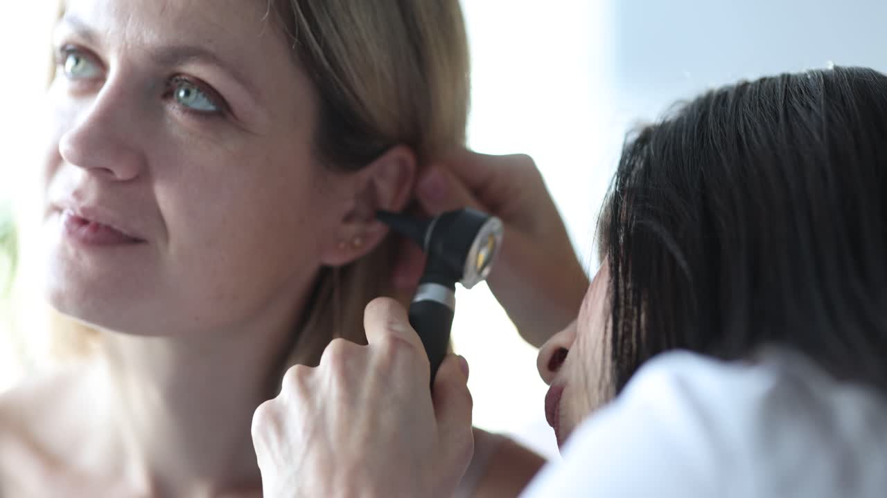 Doctor Examining Patient's Ear with Otoscope