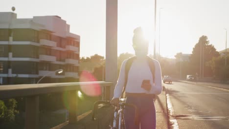 Mixed-race-woman-walking-next-to-her-bike-on-the-street