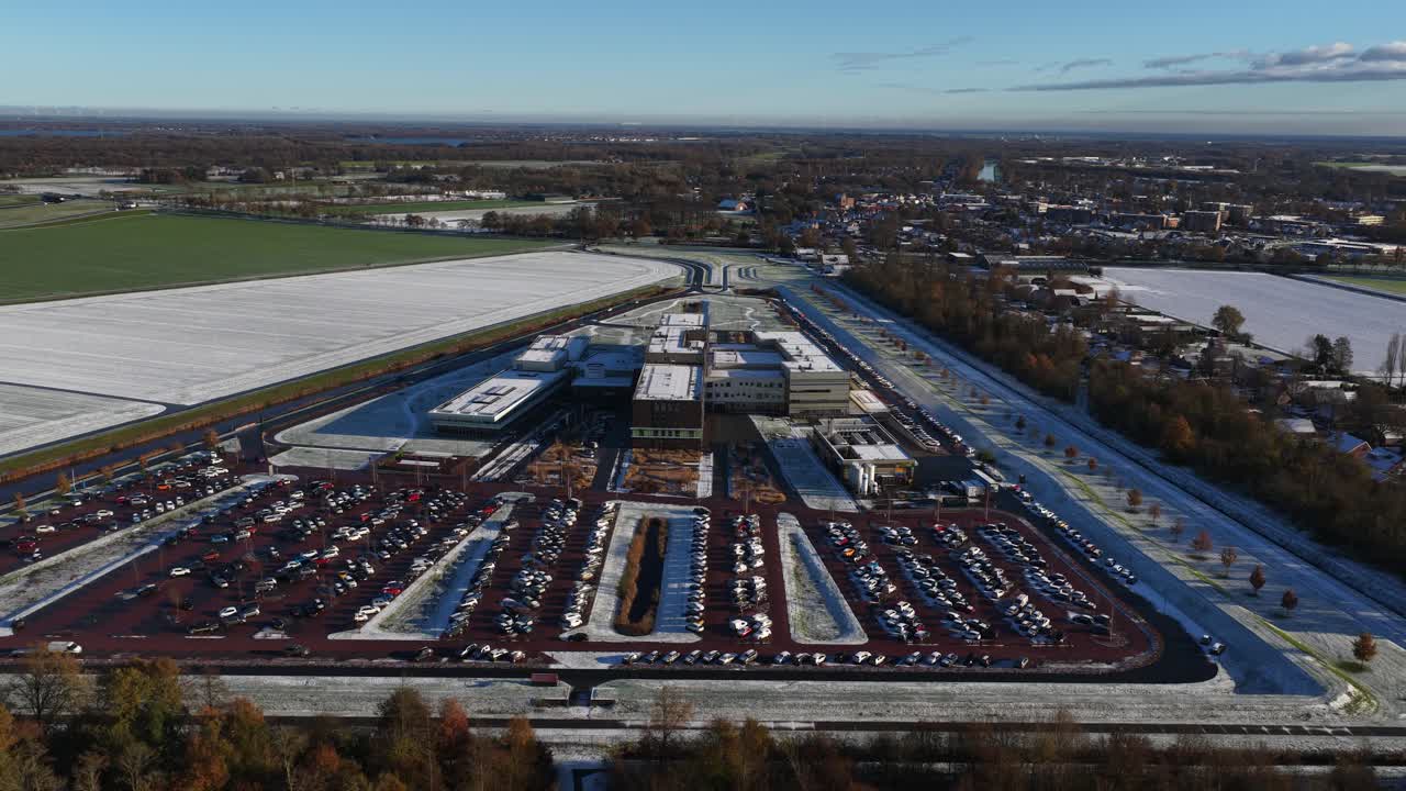 Aerial drone video footage of the modern Ommelander Hospital in Scheemda, Groningen, in a winter landscape. The facility is a sustainable, energy-efficient, and welcoming healthcare building