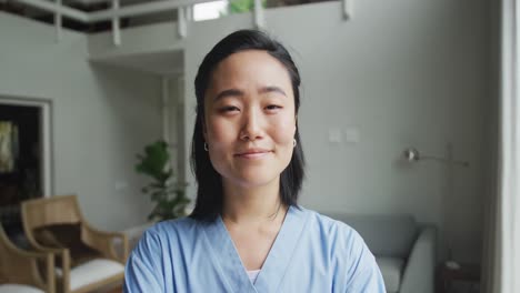 Portrait-of-happy-asian-female-nurse-at-work-in-hospital,-smiling-to-camera