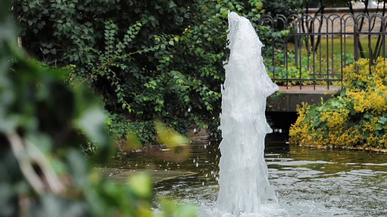 un primer plano de una hermosa fuente de agua del jardín que salpica en un estanque tranquilo