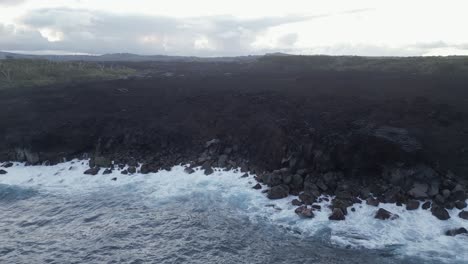 aerial retreats from steaming hot black lava flow on hawaii coast