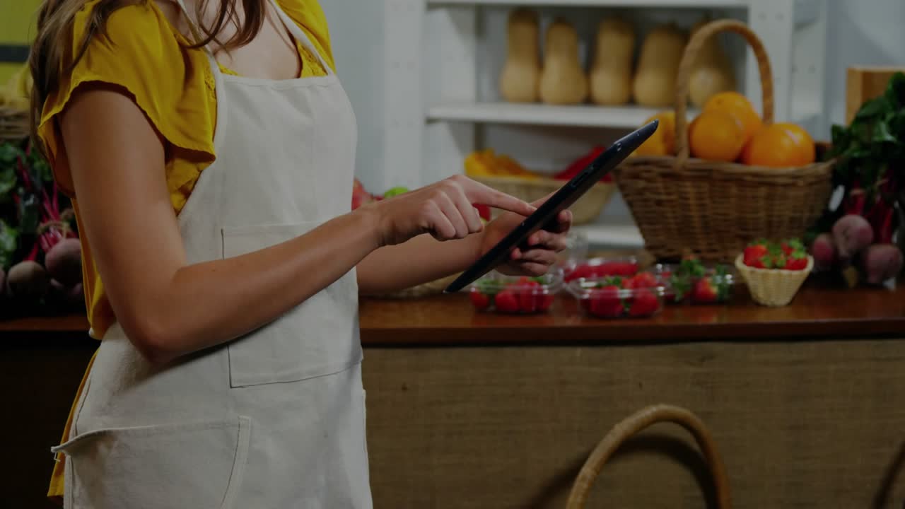 Vendor tapping tablet, updating inventory, clear grid overlays growing over tablet and produce