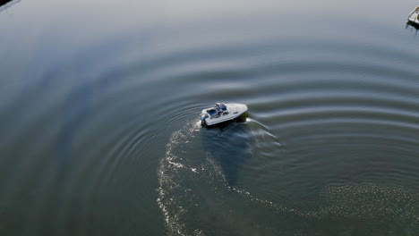 Drone-Aéreo-Circulando-Alrededor-De-Una-Pequeña-Lancha-Motora-Blanca-Yate-Barco-Barco-Que-Tiene-Problemas-Con-El-Motor-Que-Tiene-Falla-Del-Motor-En-El-Océano-De-Agua-Cerca-De-Un-Barco-De-Vela-Puerto-Muelle-Junto-Al-Mar-Capitán-Frustrado