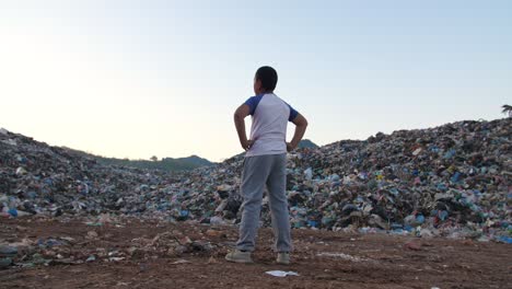 a child facing a mountain of waste