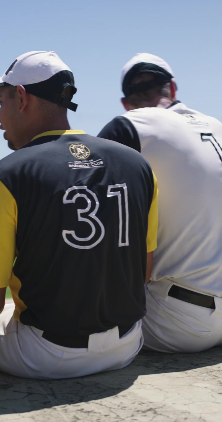Baseball Players Sitting on Dugout Bench During Game