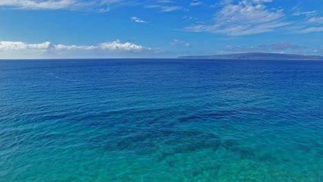 panning aerial shot of a snorkeler in maui hawaii in beautiful with blue water, sand and coastline