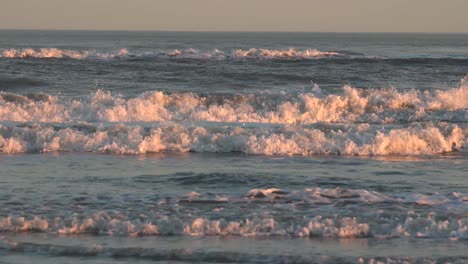 bright sunset over the waves rolling to the beach