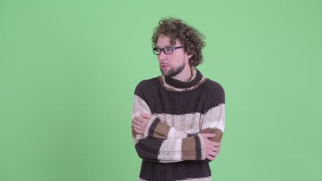 un joven guapo con barba y cabello rizado.