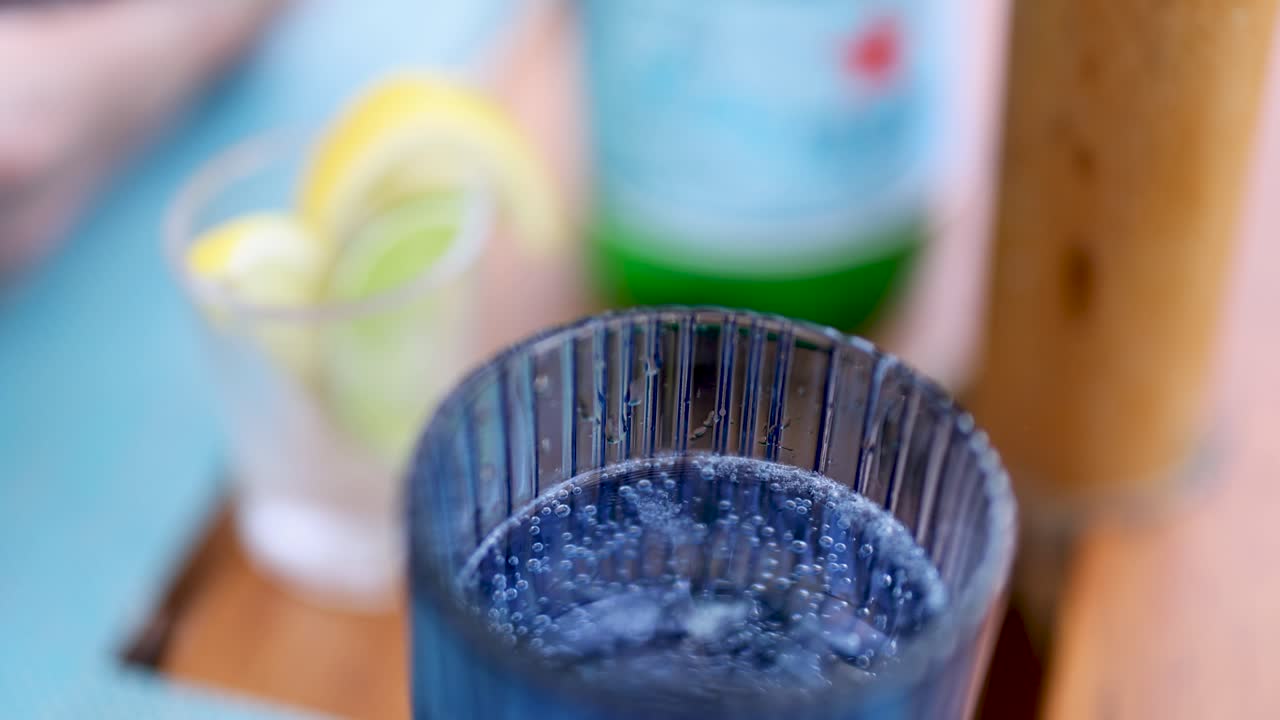 레몬 장식으로 유리잔에 있는 버블링 소다의 클로즈업으로, 상쾌한 질감과 생생한 색을 강조합니다.