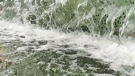 close-up or fountain water drops to small pool in the city