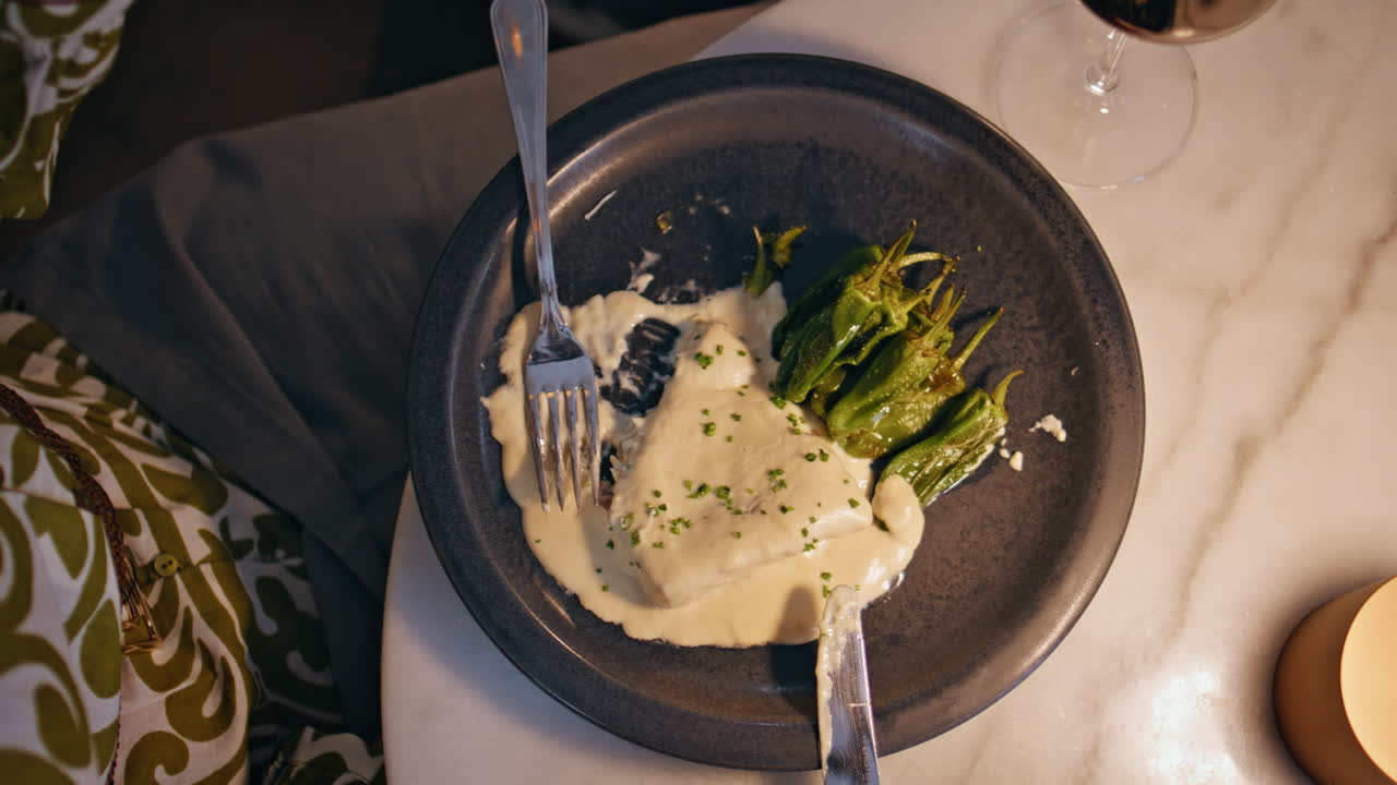 Closeup luxury restaurant dish with green peppers served on plate. Unknown woman