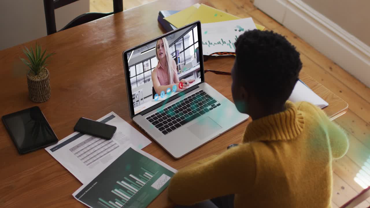 Animation of graphs over african american woman having video call on laptop