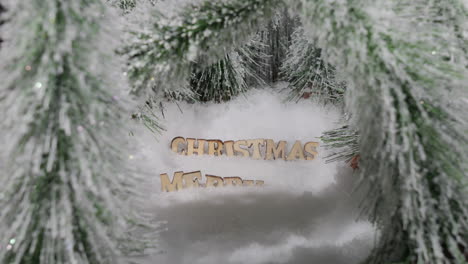 snowing over merry christmas greeting surrounded by trees