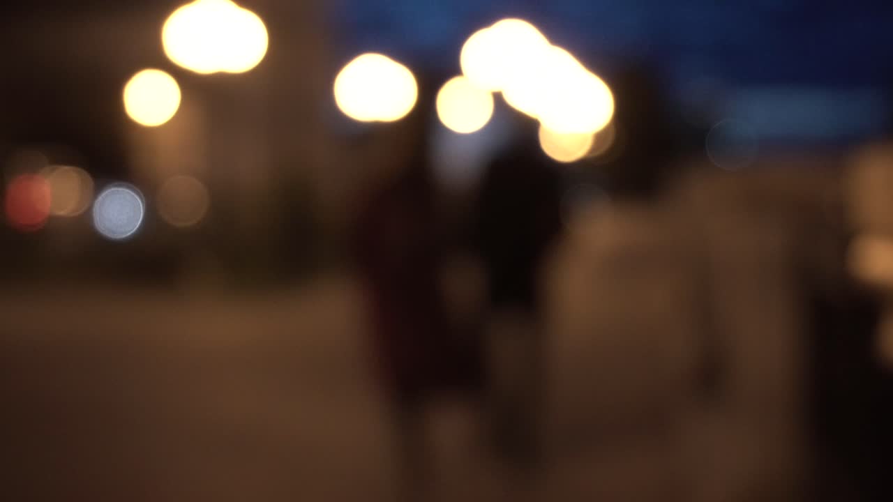 고 있는 사람 들 과 함께 흐릿 한 밤 도시 장면