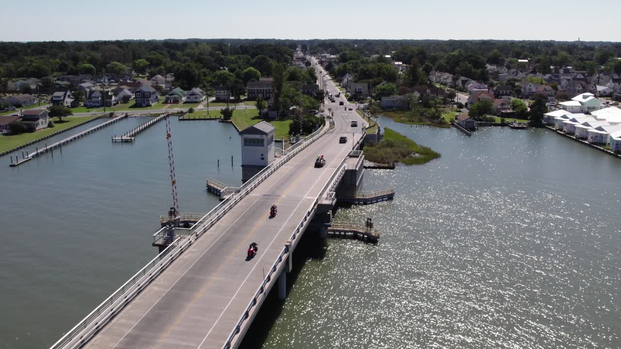 오토바이와 자동차가 다리를 건너서 chincoteague island 버지니아로 향합니다.