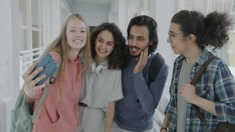 students taking a selfie in a university hallway