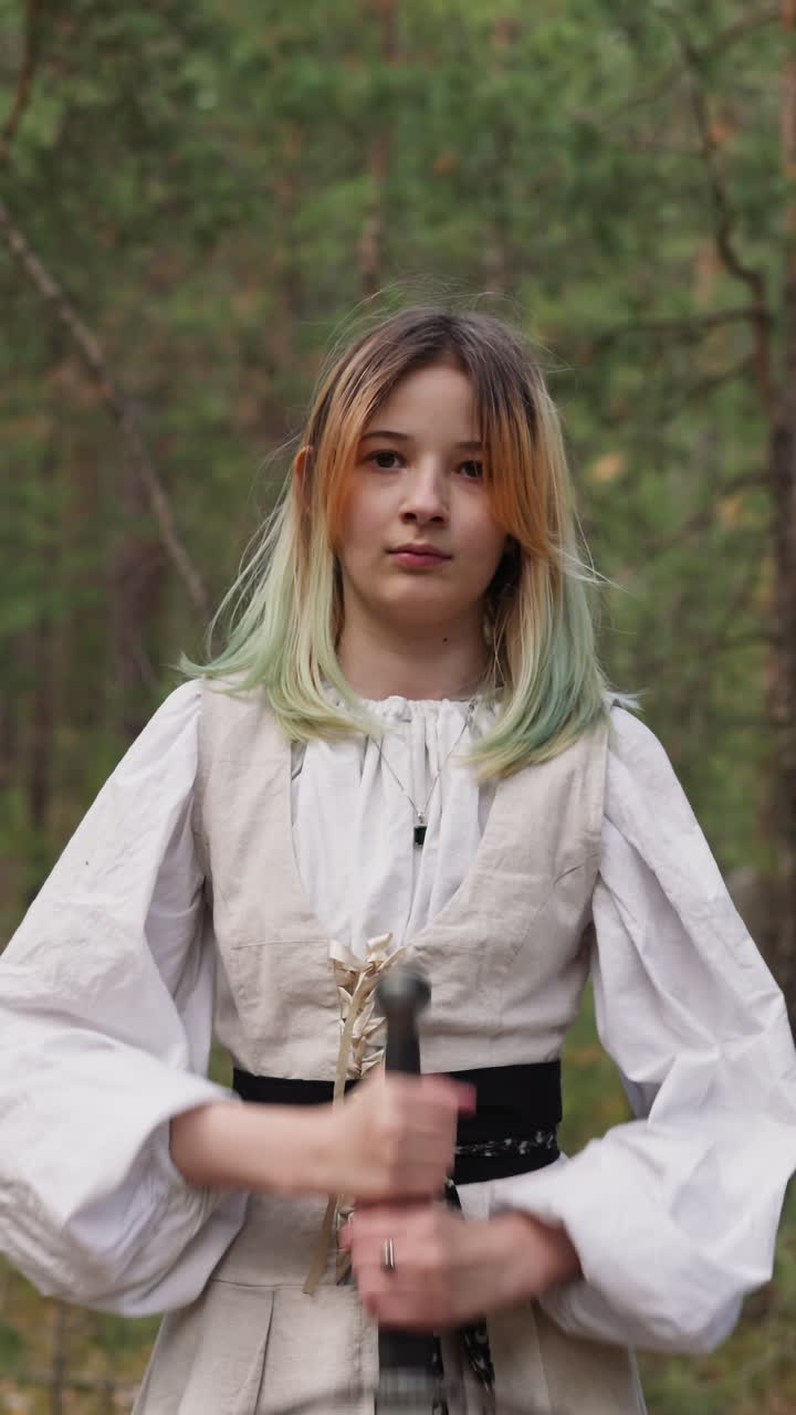 숲속에서 금발의 젊은 여성이 땅에 칼을 고, 톨킨주의자