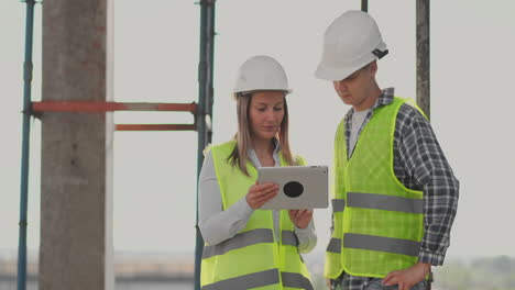 construction worker and engineer talking at construction site site. workers in helmets at building area. portrait of construction engineers working on building site. concept of modern construction