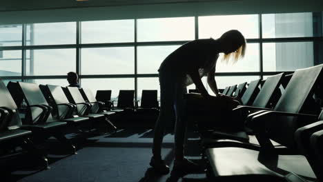 mujer cierra la maleta en la terminal del aeropuerto