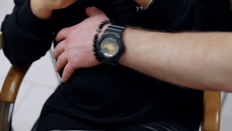 male hand with a black wristwatch strokes pregnant lady's belly. cropped image of a couple expecting a baby soon. close up.