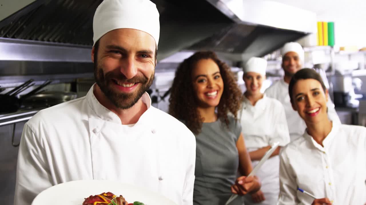 equipo de cocineros con uno presentando un plato