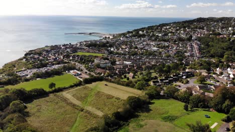 Luftaufnahme-über-Felder-Mit-Blick-Auf-Die-Stadt-Lyme-Regis-Im-Hintergrund