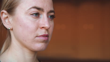 close up of a blonde woman's face looking to side with a focused and determined expression