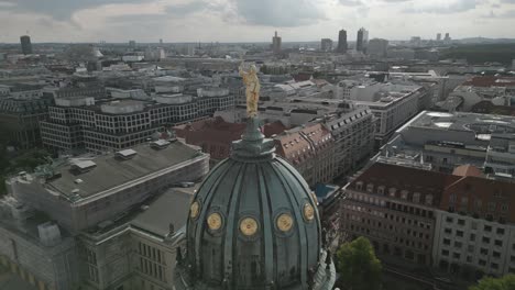 Aerial-view-of-cathedral-steeple,-golden-statue-on-top,-sunny-Berlin-cityscape