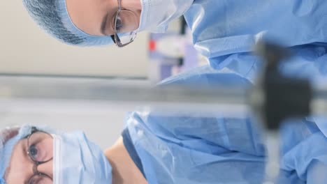 a cesarean operation is performed by a surgeon dressed in protective clothing a caesarean section operation is performed by a surgeon and an assistant dressed in protective clothing modern mother and child clinic