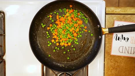 saut ing peas carrots and ham in oil