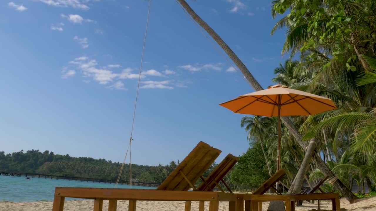 camas de playa con sombrilla en la playa de arena blanca