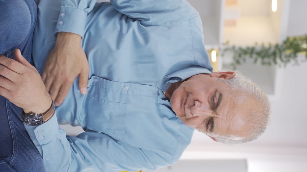 video vertical de un anciano con náuseas.