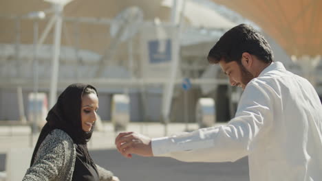 young muslim couple having fun dancing outside on sunny day.