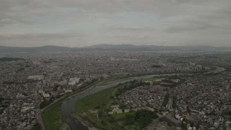 Luftdrohnenaufnahme-Von-Kyoto-Bei-Sonnenuntergang-In-Der-Nähe-Eines-Flusses,-Japan,-Asien