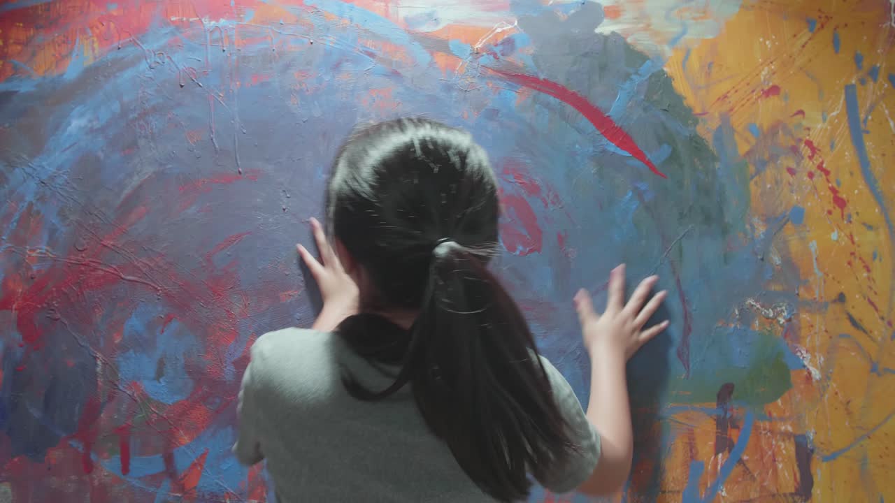 Child interacting with a large wall painting