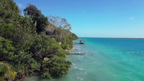 aerial: beautiful homes with private docks on tropical bacalar lagoon