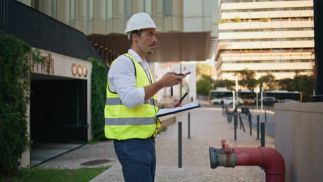 hardhat man worker turning walkie-talkie working alone. plumber using radio