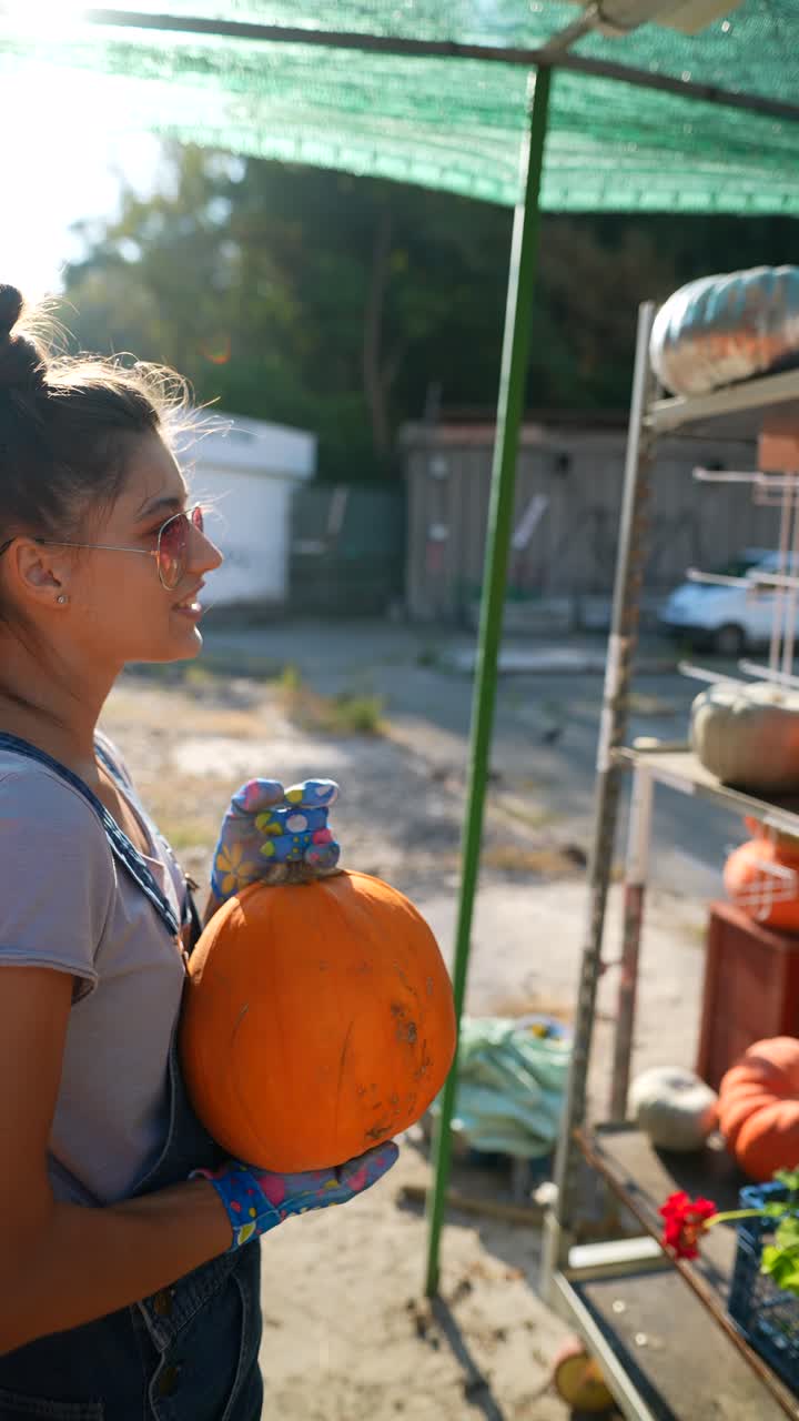 mujer sosteniendo una calabaza en un mercado al aire libre